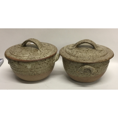 493 - A pair of lidded stoneware pottery soup bowls with lug handles of fluted speckled design. Apparently... 