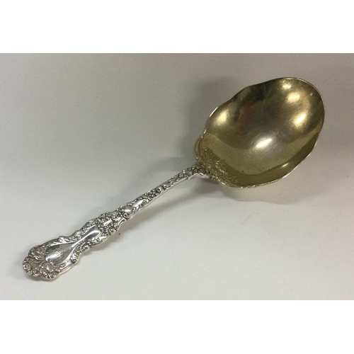 112 - A chased silver serving spoon with embossed flowers to gilt bowl. Apparently unmarked. Approx. 88 gr... 