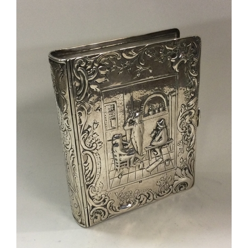 176 - A 19th Century Dutch silver box in the form of a book, heavily chased with musicians. London import ... 