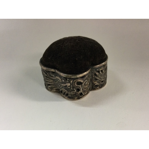 344 - WANG HING: A heavy Chinese silver pin cushion with chased floral decoration. Approx. 25 grams. Est. ... 