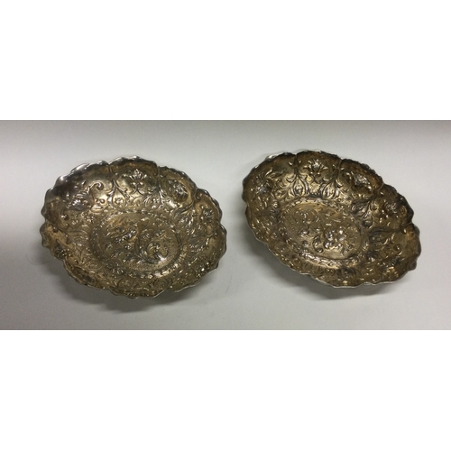 462 - A good pair of Victorian silver bonbon dishes decorated with flowers in relief. London. By WC. Appro... 