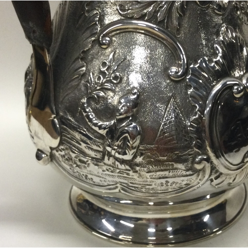 119 - A good quality Georgian silver baluster shaped jug with hinged top decorated with figures. London 17... 