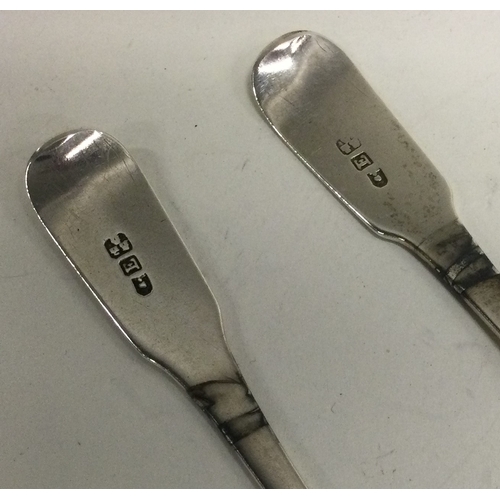 129 - NEWCASTLE: A pair of fiddle pattern silver dessert spoons. Approx. 63 grams. Est. £20 - £30.