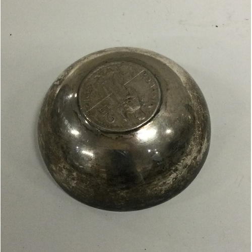 136 - A silver tumbler with early coin to centre. Approx. 38 grams. Est. £50 - £80.