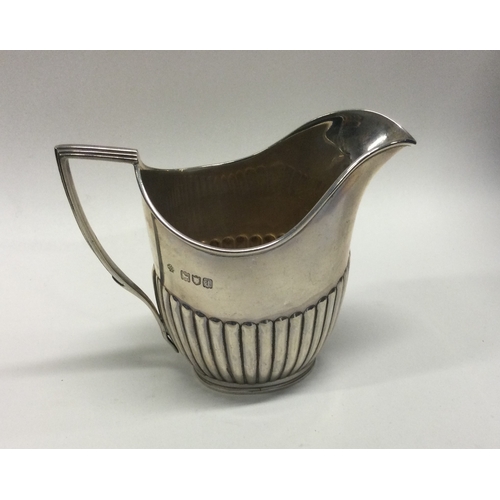 19 - An Edwardian silver half fluted cream jug. London. Approx. 159 grams. Est. £40 - £60.