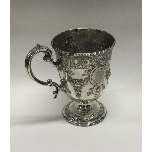 23 - A Victorian silver mug with embossed decoration chased with flowers and vines. Sheffield 1867. By Ma... 