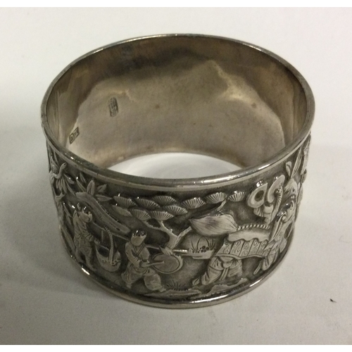 180 - A good Chinese silver napkin ring decorated with figures. Approx. 30 grams. Est. £20 - £30.