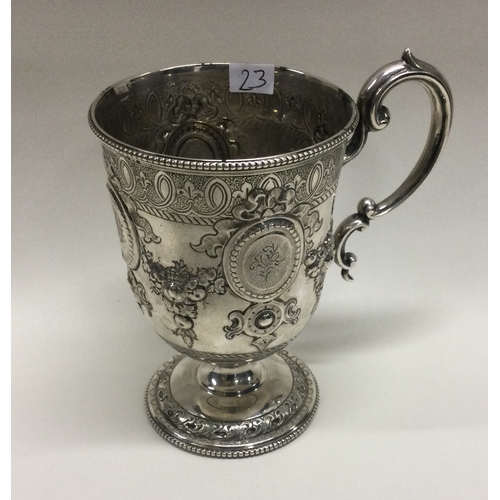 23 - A Victorian silver mug with embossed decoration chased with flowers and vines. Sheffield 1867. By Ma... 