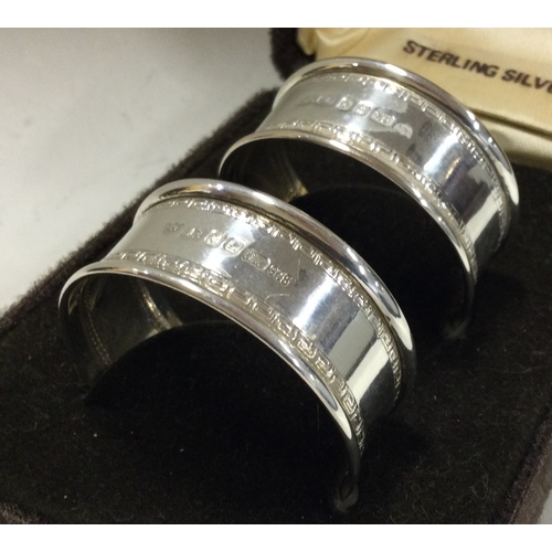 166 - A cased pair of silver napkin rings. London 1985. by A Norman. Approx. 19 grams. Est. £30 - £50.