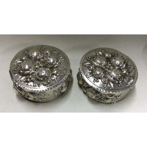 168 - A pair of early German silver boxes embossed with fruit. Approx. 244 grams. Est. £250 - £300.