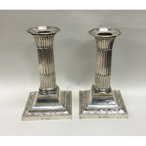 179 - A pair of silver candlesticks with fluted stems. London. Approx. 934 grams. Est. £30 - £50.