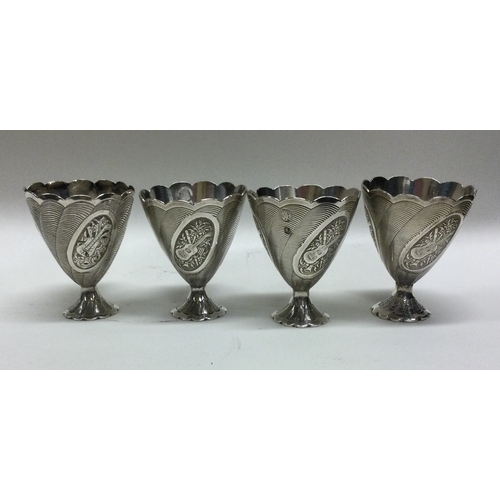 203 - A set of four Continental silver egg cups decorated with flowers. Approx. 171 grams. Est. £30 - £40.