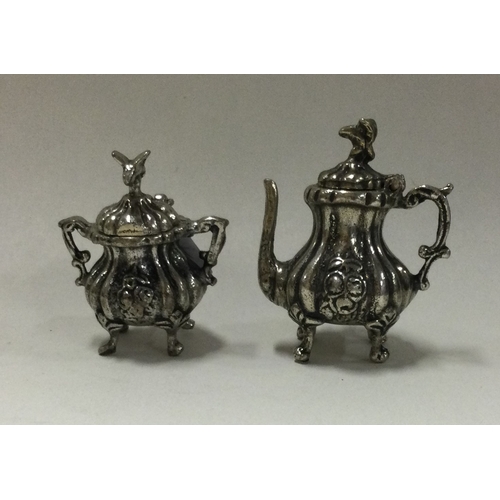 234 - A heavy miniature cast silver teapot together with matching bowl. Approx. 29 grams. Est. £20 - £30.