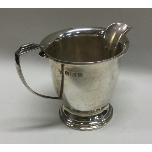 42 - A stylish silver cream jug on spreading foot. Birmingham. By S&Co. Approx. 104 grams. Est. £30 - £40... 