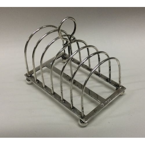 61 - A good six bar silver toast rack on ball feet. Sheffield. by SW. Approx. 104 grams. Est. £40 - £60.