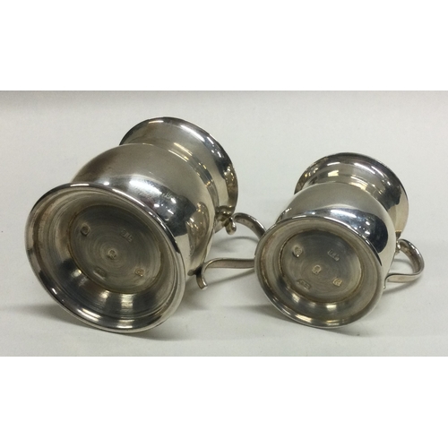 114 - A pair of tapering silver miniature mugs. London. Approx. 66 grams. Est. £30 - £50.