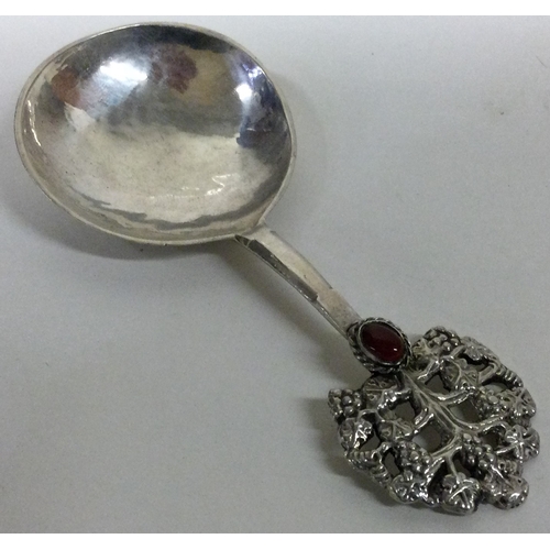 128 - A rare Arts and Crafts silver and red stone spoon pierced and embossed with grapes. London 1917. By ... 