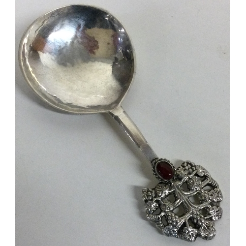 128 - A rare Arts and Crafts silver and red stone spoon pierced and embossed with grapes. London 1917. By ... 