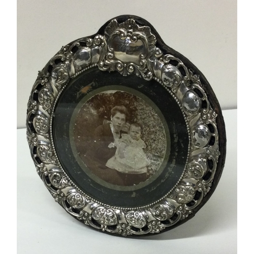 165 - A decorative Edwardian silver circular photo frame with pierced decoration. Birmingham 1902. By Henr... 