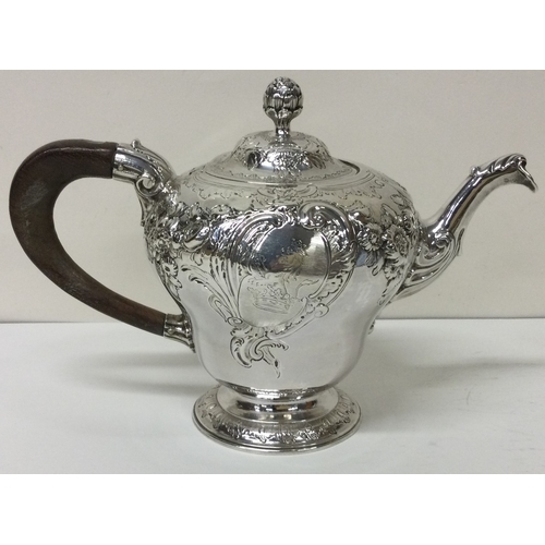 174 - An early George II silver crested chased teapot. London 1748. By John Swift.  Approx. 605 grams. Est... 