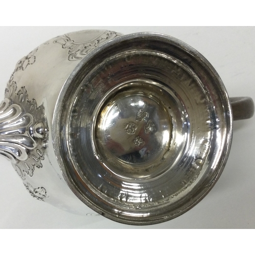 174 - An early George II silver crested chased teapot. London 1748. By John Swift.  Approx. 605 grams. Est... 