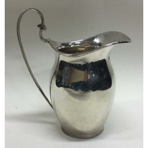 183 - A Georgian style silver cream jug with loop handle. London. Approx. 76 grams. Est. £100 - £150.