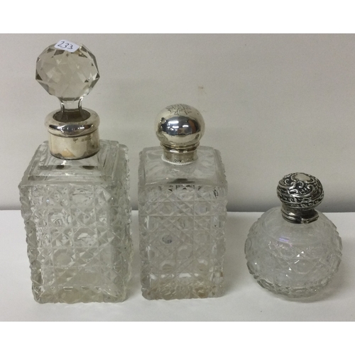 233 - A group of three cut glass and silver mounted scent bottles.  Est. £20 - £30.