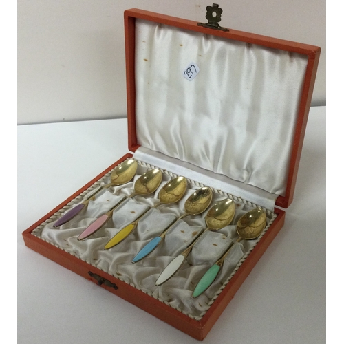 297 - A cased set of six Danish silver gilt and enamel spoons. Approx. 61 grams. Est. £100 - £150.