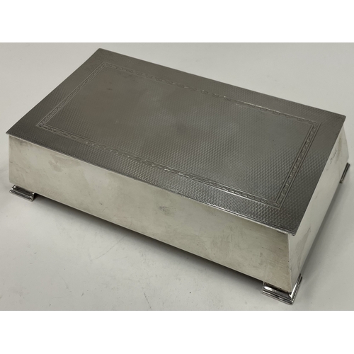 36 - A large engine turned silver cigar box on feet. Birmingham 1958. By Adie Brothers. Approx. 606 grams... 