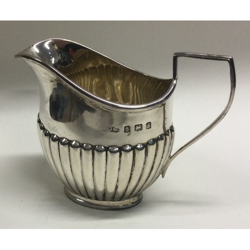 95 - A small silver half fluted cream jug. Birmingham. Approx. 67 grams. Est. £30 - £50.