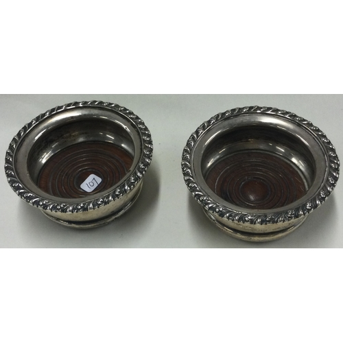 107 - A pair of silver and wooden bottle coasters. Birmingham 1911. Approx. 169 grams. Est. £100 - £200.