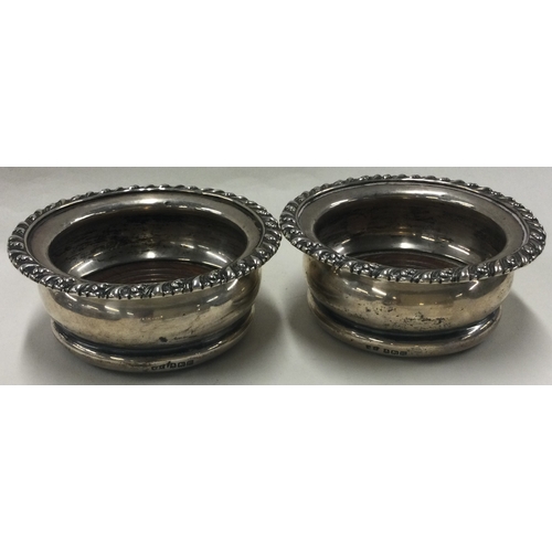 107 - A pair of silver and wooden bottle coasters. Birmingham 1911. Approx. 169 grams. Est. £100 - £200.