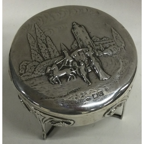 315 - A chased silver hinged box on feet embossed with a horses and carriage scene. London 1924. By Willia... 