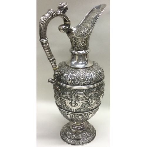 370 - GLASGOW: A large Victorian Cellini silver wine jug embossed with birds, animals, figures and vines. ... 