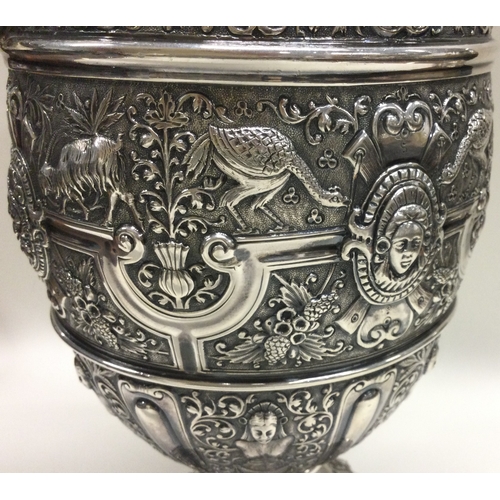 370 - GLASGOW: A large Victorian Cellini silver wine jug embossed with birds, animals, figures and vines. ... 