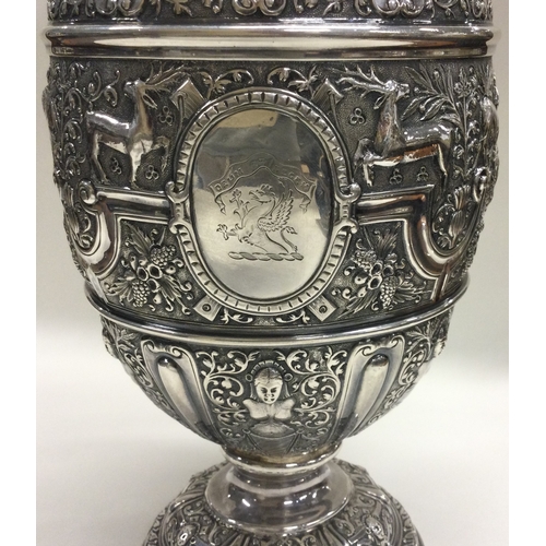 370 - GLASGOW: A large Victorian Cellini silver wine jug embossed with birds, animals, figures and vines. ... 