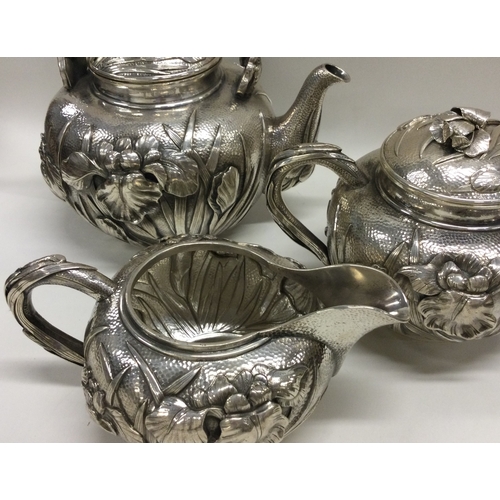 386 - MEJI: A fine 19th Century Japanese silver three piece tea set with chased decoration. Approx. 1250 g... 