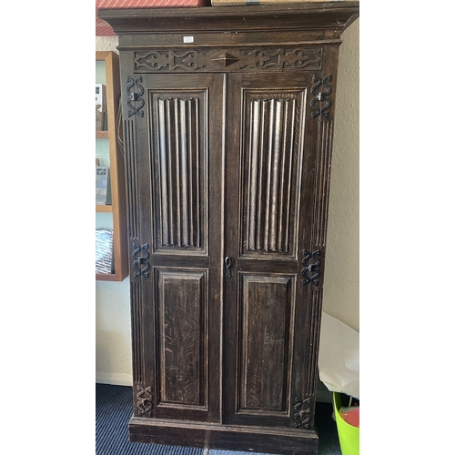 11 - A narrow oak hall cupboard. Est. £50 - £80.