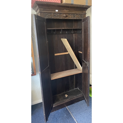 11 - A narrow oak hall cupboard. Est. £50 - £80.