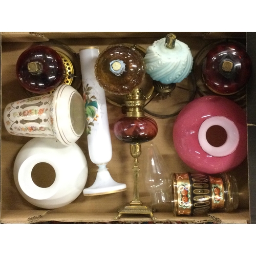 51 - A box containing old oil lamps and shades. Est. £10 - £20.