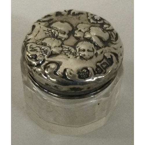 11 - A silver and glass box decorated with cherubs. Birmingham 1901. Est. £20 - £30.