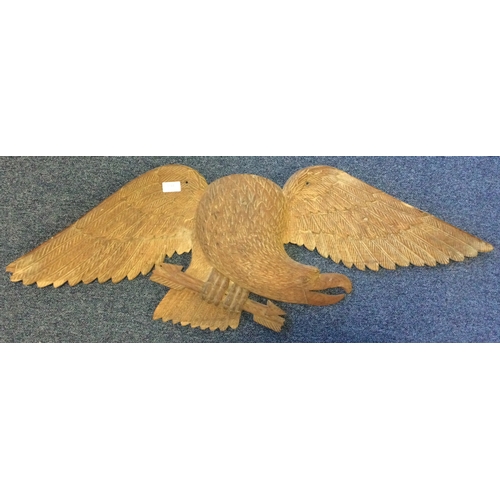 1344 - A large Continental wooden panel depicting an eagle with outstretched wings. Est. £80 - £120.