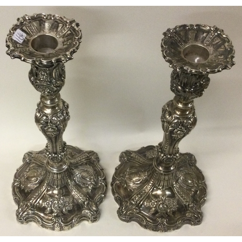 164 - A large ornate pair of Victorian silver candlesticks embossed with flowers. Sheffield 1848. By Cresw... 