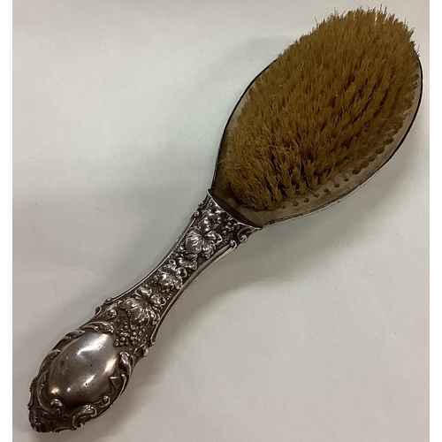 169 - A novelty silver clothes brush with vine pattern. Birmingham 1902. By HCF. Est. £40 - £60.