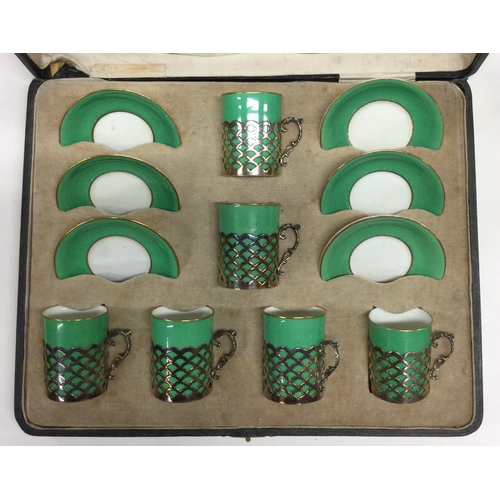 24 - A large cased set of Aynsley coffee cups and saucers with silver mounts. Est. £80 - £120.