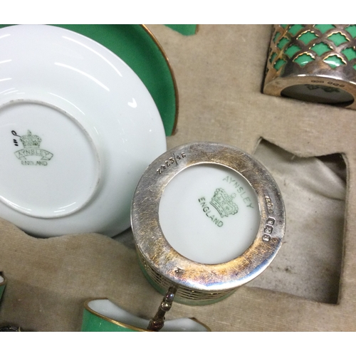 24 - A large cased set of Aynsley coffee cups and saucers with silver mounts. Est. £80 - £120.