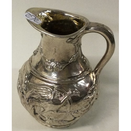 262 - A fine chased Victorian silver jug embossed with birds. Approx. 83 grams. Est. £60 - £80.