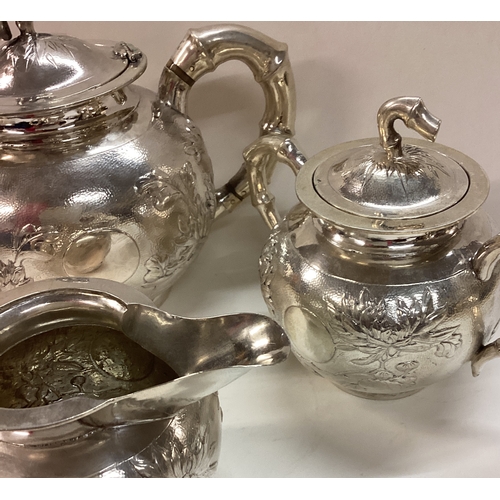 286 - A Chinese export silver three piece tea service. Circa 1900. Marked to base. By LS. Approx. 784 gram... 