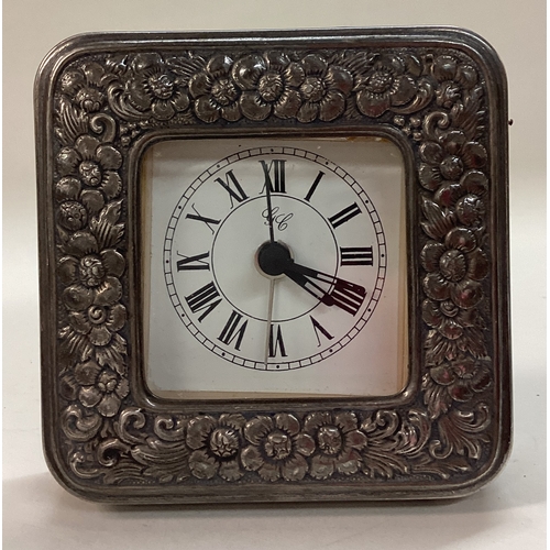 295 - A chased silver clock. Marked to base. Est. £40 - £60.