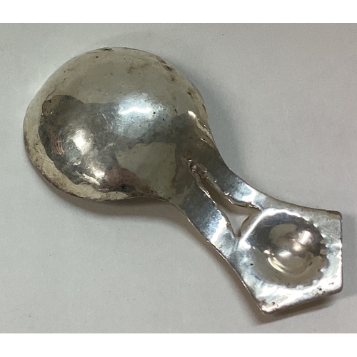 327 - An Arts and Crafts silver caddy spoon with hammered handle. Approx. 14 grams. Est. £30 - £50.